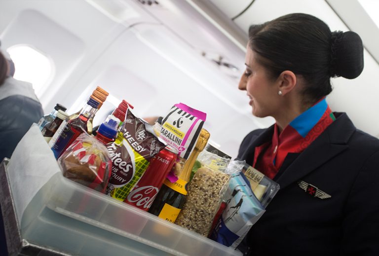 flight attendant offering snacks to passangers