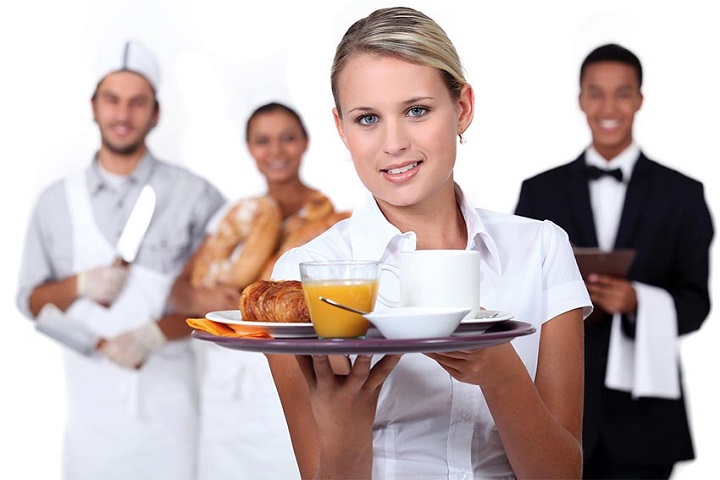 woman holding breakfast with team behind her
