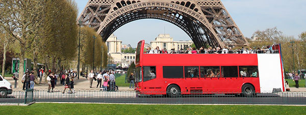 red bus in front of eiffel tower