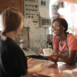 woman giving coffee to customer